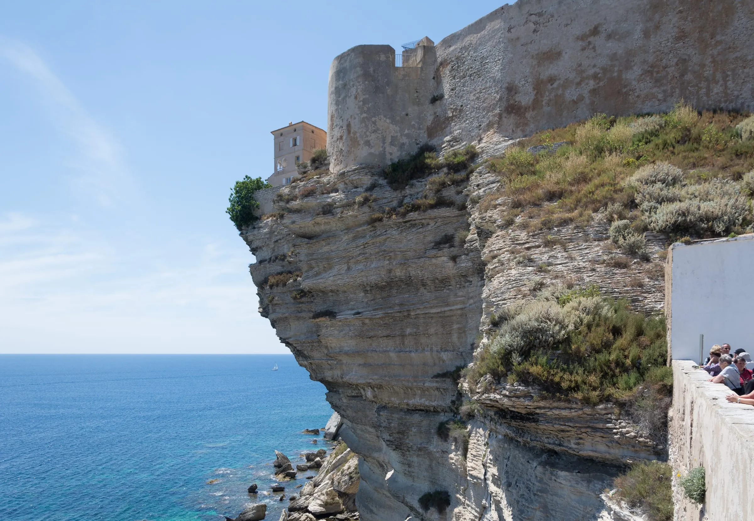 Die Oberstadt von Bonifacio steht auf einer weissen Kalkklippe, einzelne Häuser ragen über die Kante hinaus aufs Meer